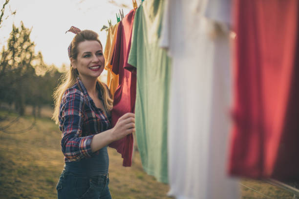 Retro styled girl doing laundry in a backyard of her home on a beautiful sunny day