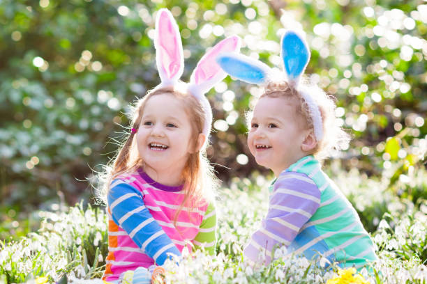 istock Kids on Easter egg hunt in blooming spring garden 647793606