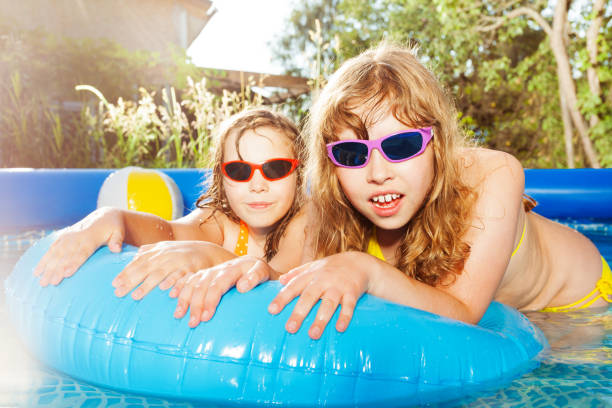 istock Two girls swimming in the pool with  rubber ring 647798590