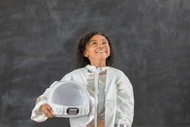 istock Cute elementary student wears astronaut costume at school 647798828