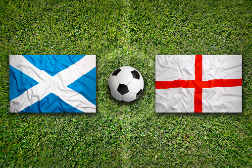 Scotland vs. England flags on green soccer field
