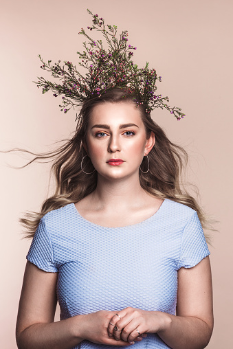 Beautiful young woman with flowers as a crown in her hair