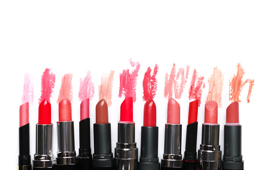 Set of colorful lipsticks with smudged samples partially isolated on white background. Top view point.