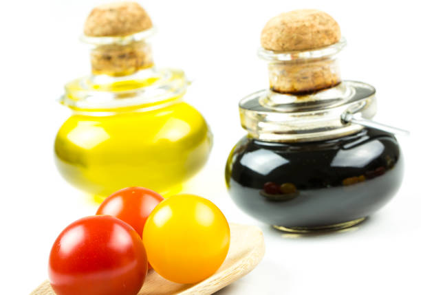 Closeup of varieties of colorful tomatos with bottle of olive oil and vinegar