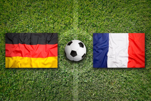 Germany vs. France flags on a green soccer field