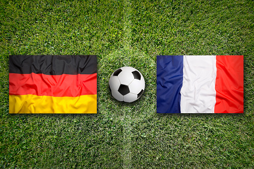Germany vs. France flags on a green soccer field