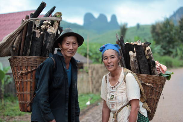 people with fire wood near the Village of Muang Phou Khoun on the Nationalroad 13 on the way from Vang Vieng to Luang Prabang in Lao in southeastasia.