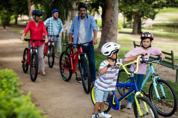 istock Multi-generation family walking with bicycle in park 647830858