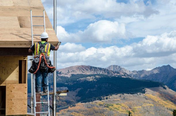 Construction worker wearing safety harness and safety line working at high place