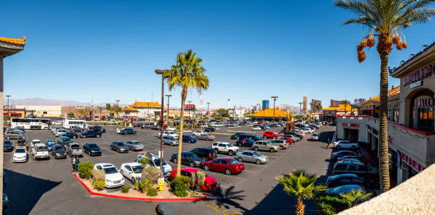 Neighborhood grocery store with rooftop HVAC system units and gas station, busy parking lots surrounding by colorful fall foliage autumn leaves in Coppell, suburbs Dallas, Texas, aerial view. USA