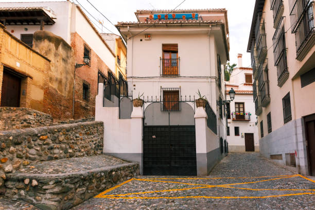 Scenic alley with traditional Spanish white houses in the old town area of Albaicin, Granada, Andalusia, Spain