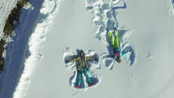 istock Couple making angel silhouette in snow 647848968
