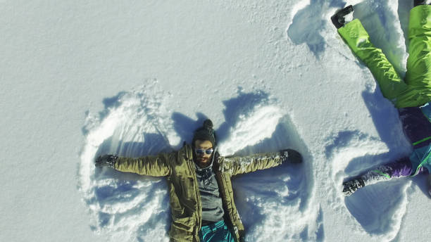 istock Couple making angel silhouette in snow 647848988