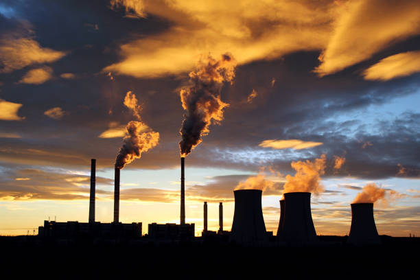 istock dramatic sunset and smoking power plant 647849788