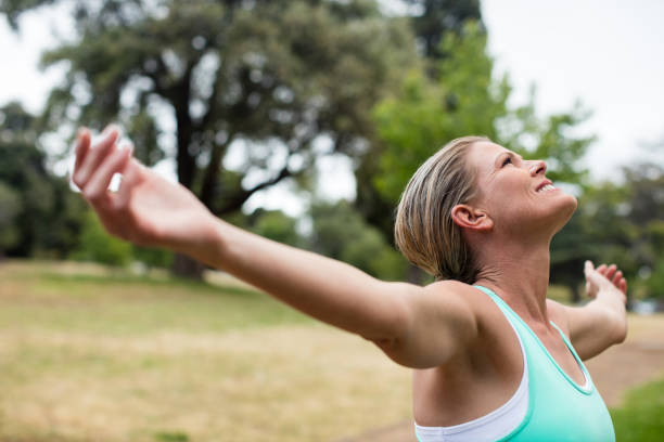 istock Female athlete with arms outstretched in park 647855900