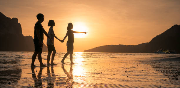 istock happy family walking on the beach 647862046
