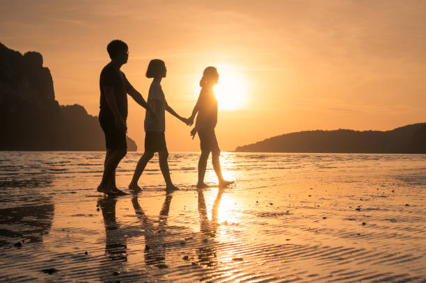 istock happy family walking on the beach 647862048