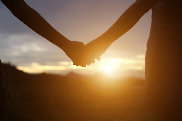 istock young couple holding hands. In Nature sunrise 647865776