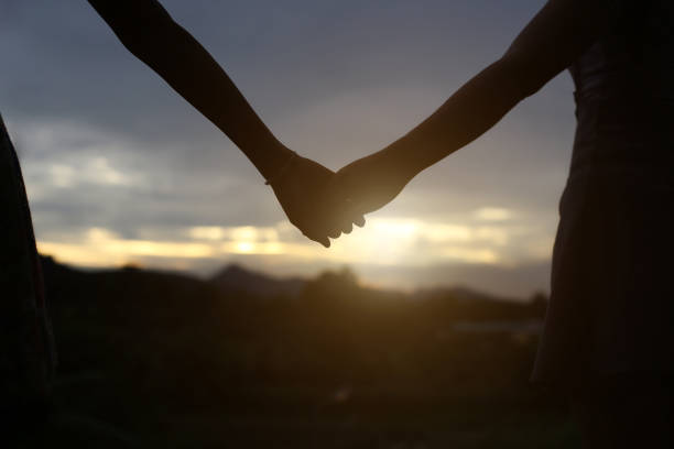istock young couple holding hands. In Nature sunrise 647865788