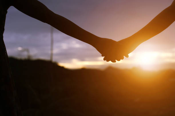 istock young couple holding hands. In Nature sunrise 647865796