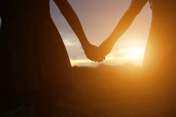 istock young couple holding hands. In Nature sunrise 647865808