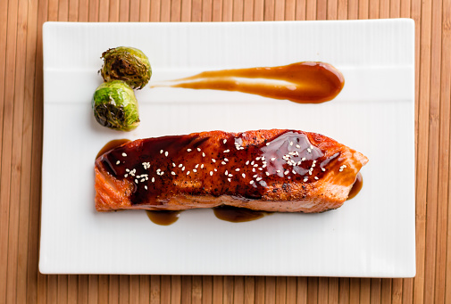 Japanese cuisine inspired dinner consisting of a grilled salmon fillet glazed in delicious teriyaki sauce (soy sauce base). Healthy brussel sprouts as sides.