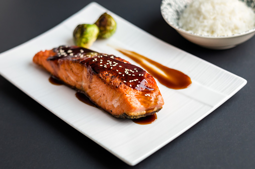 Japanese cuisine inspired dinner consisting of a grilled salmon fillet glazed in delicious teriyaki sauce (soy sauce base). Brussel sprouts and white rice as sides.