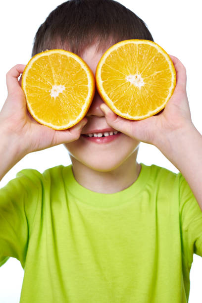 istock Happy boy with two slices orange isolated 647878782