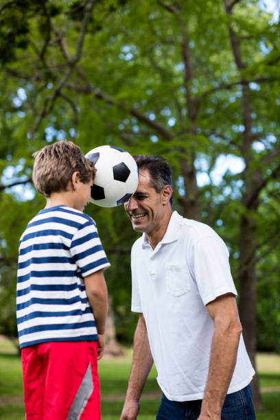 istock Father and son playing football 647956920