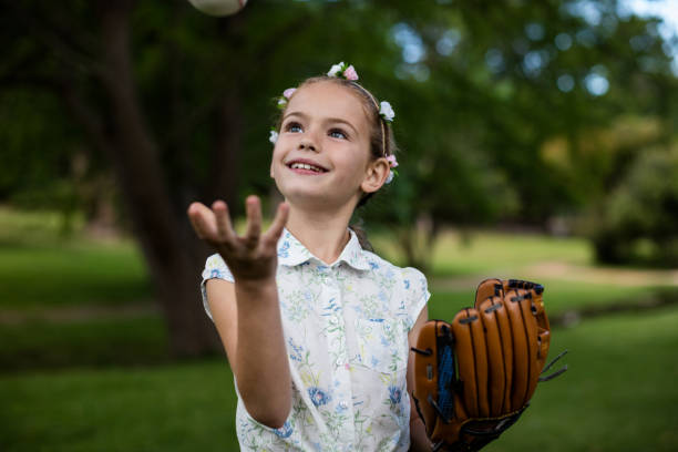 istock Cute girl with baseball in park 647957308