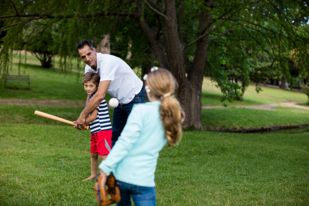 istock Family playing baseball in the park 647957596