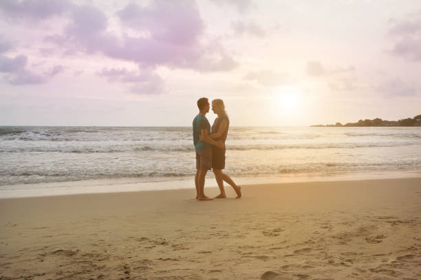 istock Beautiful couple on sunset beach hug each other and looking into eyes. 647957724