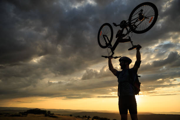 istock Cheerful biker picking up his bike at sunset 647967838