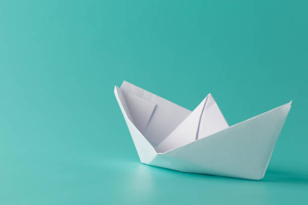 istock paper boat on aquamarine background 647972108