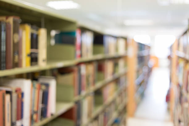 istock books on bookshelf in library, abstract blur defocused background 647974540