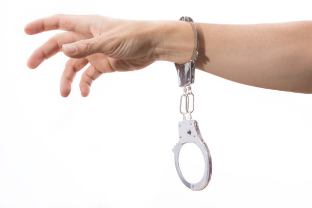 istock one hand with handcuff reaching out with palm open, on white background 647974986