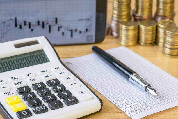 istock Metal coins and calculator on a rustic table. 647978192