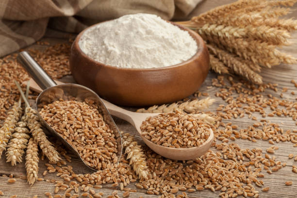 istock Ears of wheat and flour in the wooden spoon on board. Easter concept 647979708