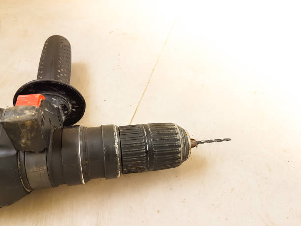 istock handle drill and screw on the dirty tile floor 647997418