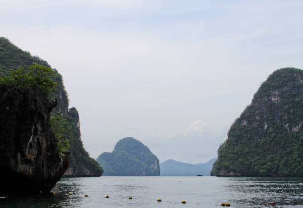 expansive view of the awesome greenish turquoise andaman sea and the scenic golden beach of railey bay krabi southern thailand during summer and monsoon season. - phuket province beach blue cliff imagens e fotografias de stock