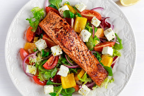 Fried Salmon steak with fresh vegetables salad, feta cheese. concept healthy food. Fried Salmon steak with fresh vegetables salad, feta cheese. concept healthy food grilled salmon stock pictures, royalty-free photos & images