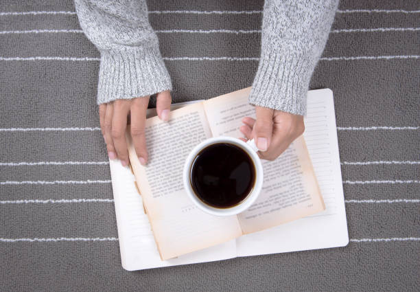istock relax woman hand with coffee cup and read a book 648001968