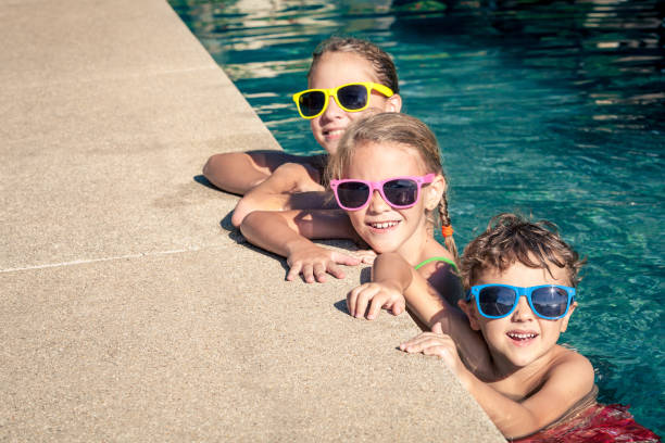 istock happy children  playing on the swimming pool at the day time. 648012000