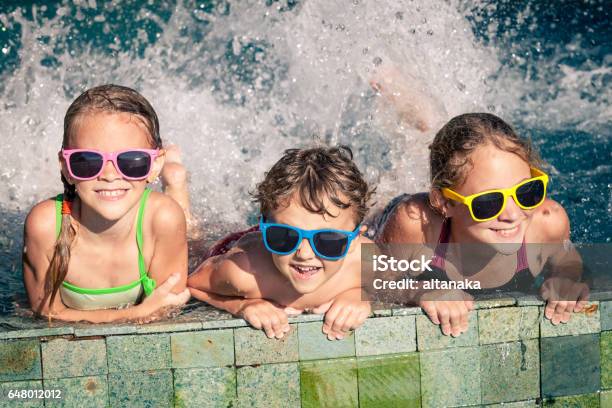 Happy Children Playing On The Swimming Pool At The Day Time Stock Photo - Download Image Now
