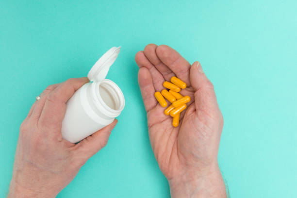 istock Medicine Bottle and Capsules in Hands 648022150