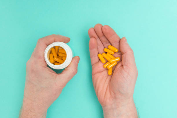 istock Hands Holding a Medicine Bottle and Capsules 648022188
