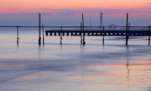 istock background color in the sea with lighthouse and pier 648024994