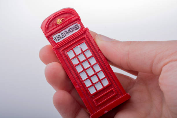 istock Hand holding a phone booth on a white background 648035842