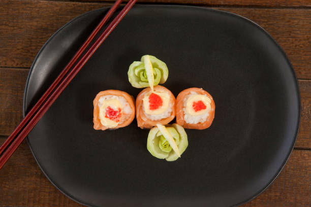 istock Three nigiri sushi served in black plate with chopsticks 648035908
