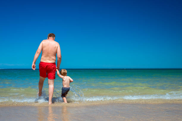 istock Grandfather with grandson on beach 648038862